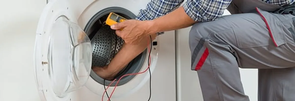 Dryer repair technician inspecting and repairing a clothes dryer in Arvada, CO